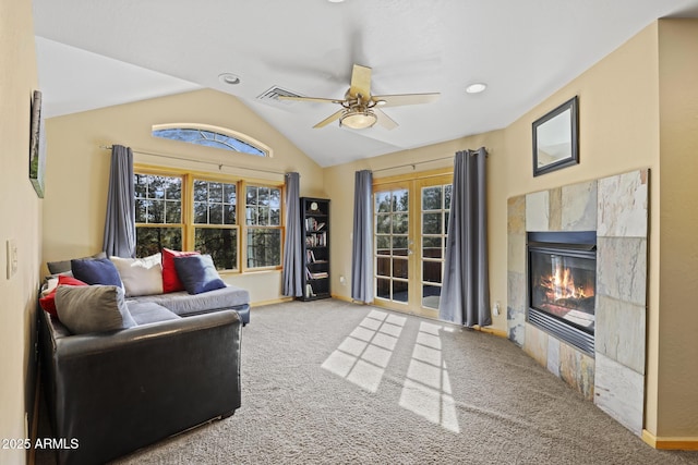 living room featuring lofted ceiling, a healthy amount of sunlight, carpet, and a high end fireplace