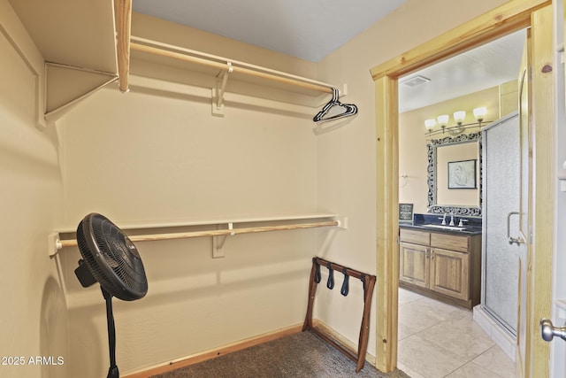 walk in closet featuring sink and light tile patterned floors