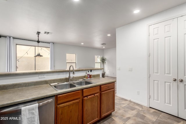 kitchen with a healthy amount of sunlight, dishwasher, brown cabinets, and a sink