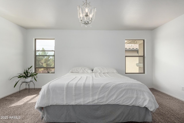 carpeted bedroom with a chandelier and baseboards