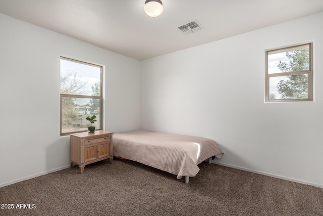 bedroom with baseboards, visible vents, and light colored carpet