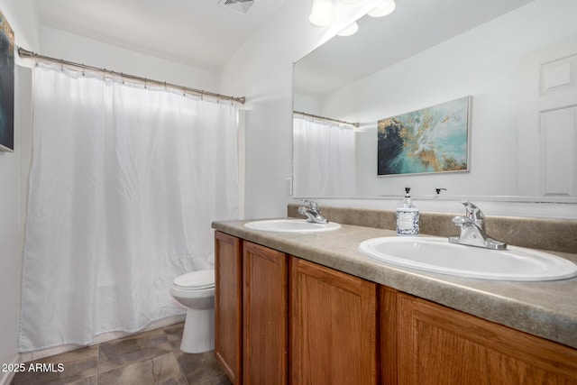 bathroom with visible vents, a sink, toilet, and double vanity