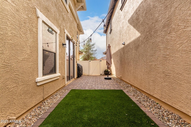 view of yard featuring a gate, a patio, and fence