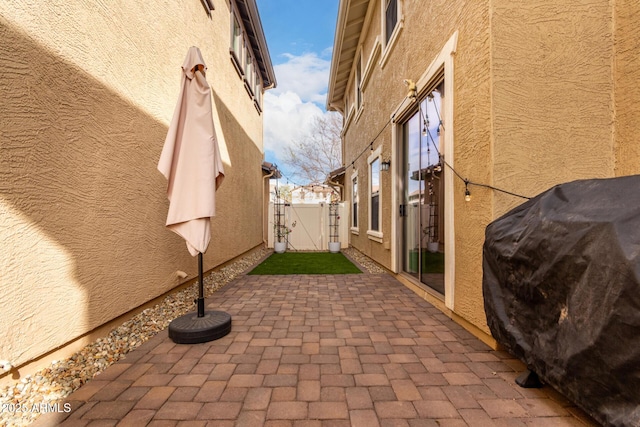 view of patio / terrace with grilling area, fence, and a gate