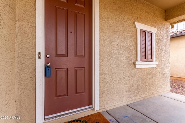 entrance to property featuring stucco siding