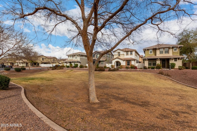 view of front of property with a residential view, a tile roof, and a front lawn