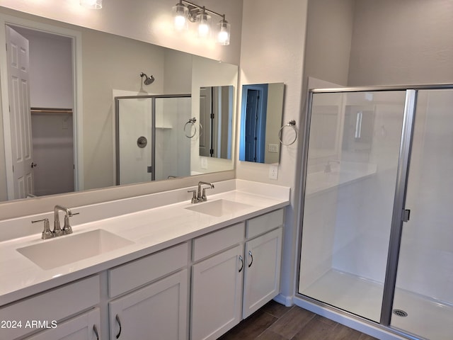 bathroom with hardwood / wood-style flooring, vanity, and walk in shower