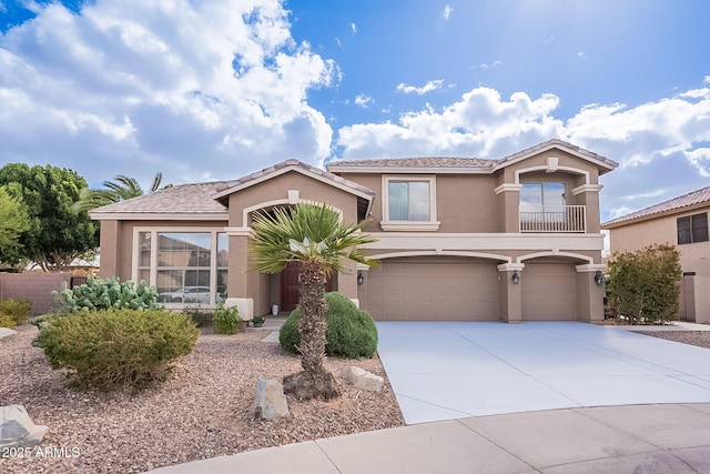 mediterranean / spanish-style home featuring a garage, concrete driveway, and stucco siding