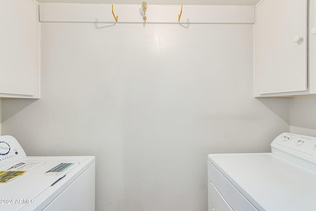 laundry room with cabinets and washer and clothes dryer