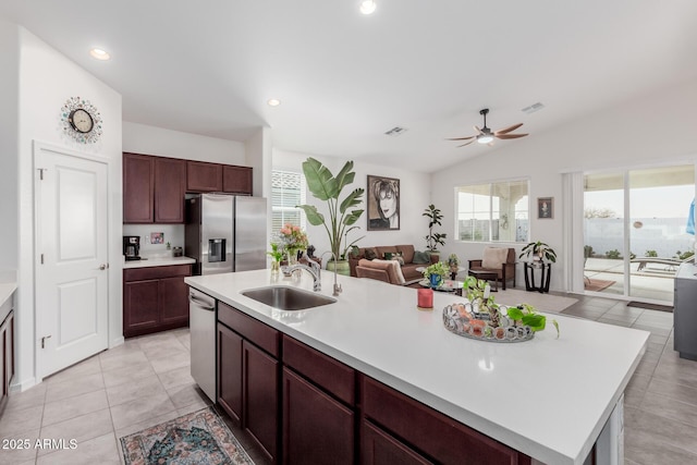 kitchen with a kitchen island with sink, sink, vaulted ceiling, ceiling fan, and stainless steel appliances
