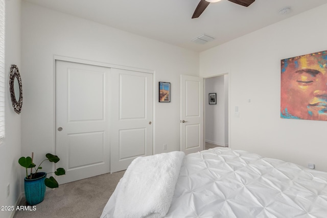 carpeted bedroom with ceiling fan and a closet