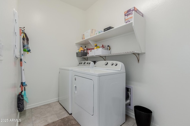 clothes washing area with washer and dryer and light tile patterned floors
