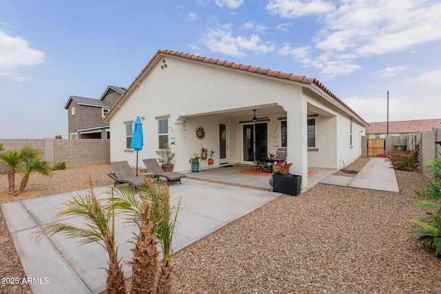 rear view of house with ceiling fan and a patio area
