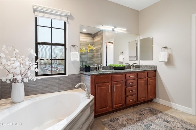 bathroom featuring tile patterned floors, vanity, and tiled bath