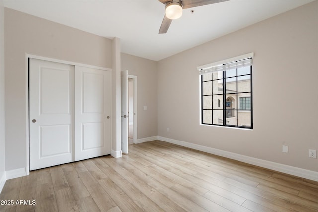 unfurnished bedroom featuring ceiling fan, a closet, and light wood-type flooring