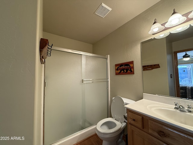 bathroom featuring toilet, a stall shower, visible vents, and vanity