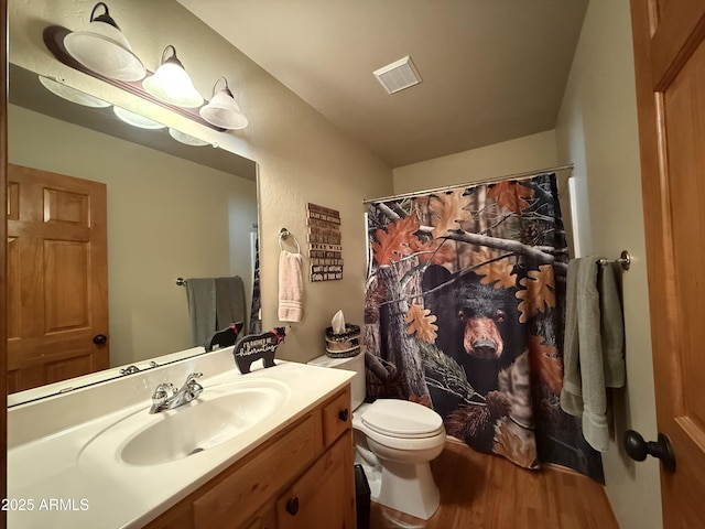 full bath featuring visible vents, a shower with shower curtain, toilet, vanity, and wood finished floors