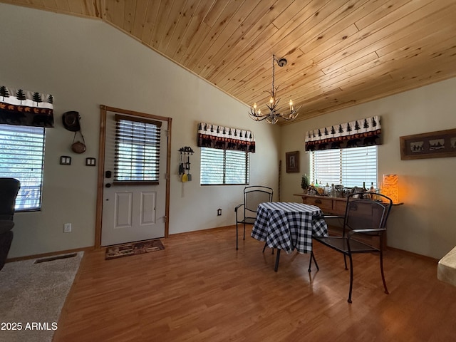 dining room featuring lofted ceiling, a healthy amount of sunlight, and an inviting chandelier