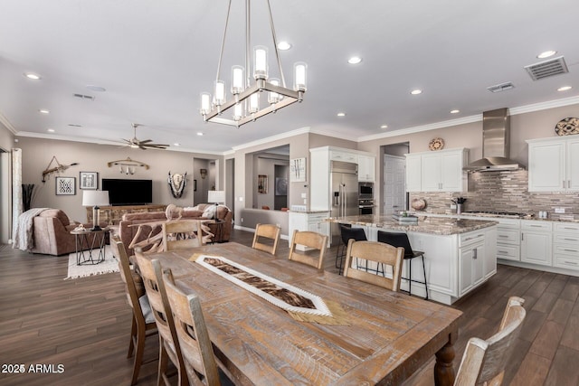 dining room with crown molding, ceiling fan with notable chandelier, and dark hardwood / wood-style floors