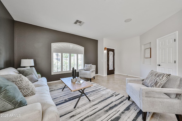 living area with baseboards and visible vents