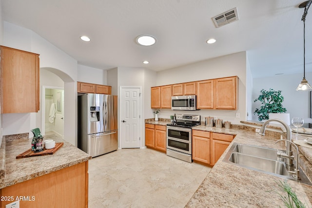 kitchen with visible vents, appliances with stainless steel finishes, arched walkways, a sink, and recessed lighting