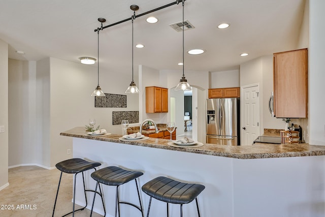 kitchen featuring hanging light fixtures, stainless steel appliances, recessed lighting, a peninsula, and visible vents