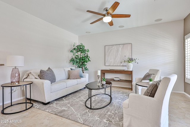 living area featuring tile patterned floors, baseboards, and a ceiling fan