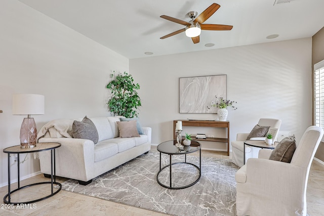 living room with a ceiling fan and baseboards