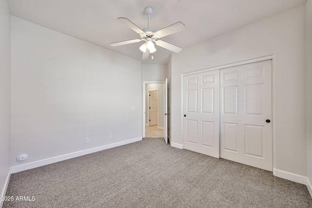 unfurnished bedroom featuring a ceiling fan, baseboards, carpet, and a closet
