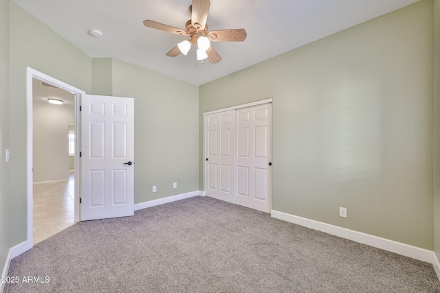 unfurnished bedroom with carpet floors, baseboards, a closet, and ceiling fan