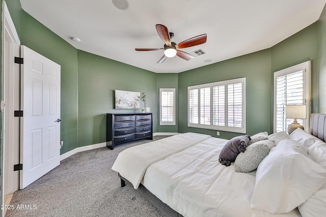 carpeted bedroom featuring visible vents, baseboards, and ceiling fan