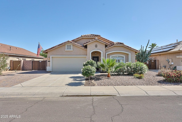 mediterranean / spanish home featuring a garage, fence, stucco siding, concrete driveway, and a tile roof
