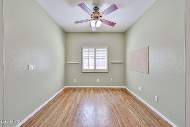 empty room featuring baseboards, a ceiling fan, and wood finished floors