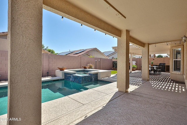 view of swimming pool featuring a patio, a pool with connected hot tub, outdoor dining area, and a fenced backyard