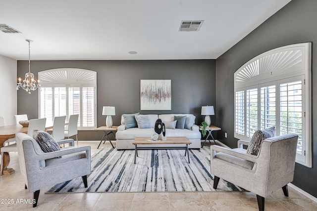 living area featuring a healthy amount of sunlight, a chandelier, and visible vents