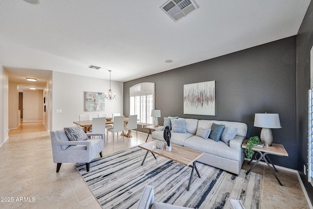 living area with visible vents, baseboards, light tile patterned floors, and an inviting chandelier