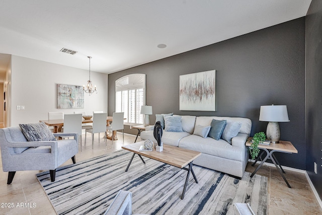 living room with baseboards, a notable chandelier, and visible vents