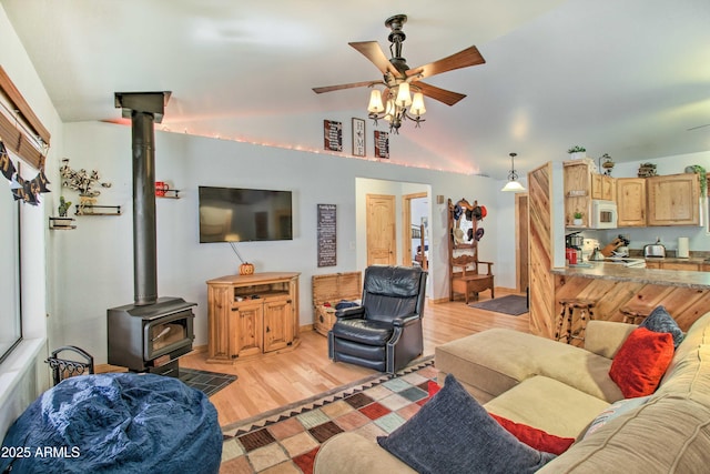3047 Ponderosa Rd, Overgaard, AZ 85933 - living area with lofted ceiling, light wood-style flooring, a wood stove, and a ceiling fan