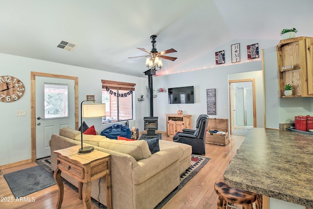 3047 Ponderosa Rd, Overgaard, AZ 85933 - living room featuring lofted ceiling, a wood stove, light wood finished floors, ceiling fan, and visible vents