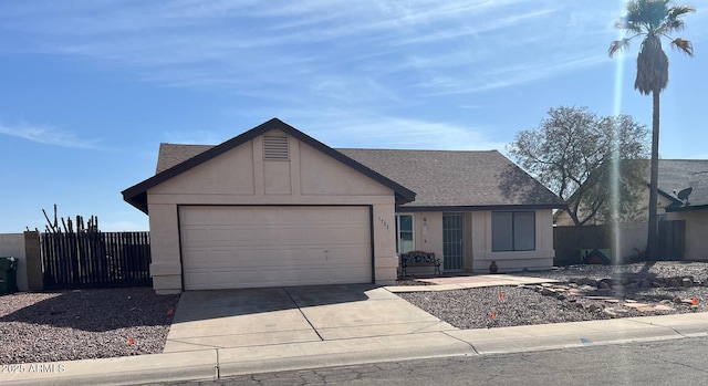 ranch-style home featuring stucco siding, concrete driveway, an attached garage, and fence