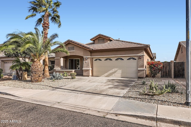 single story home with stucco siding, a tile roof, fence, concrete driveway, and an attached garage