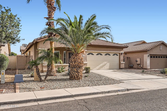 view of front of house with fence, an attached garage, stucco siding, concrete driveway, and a tile roof