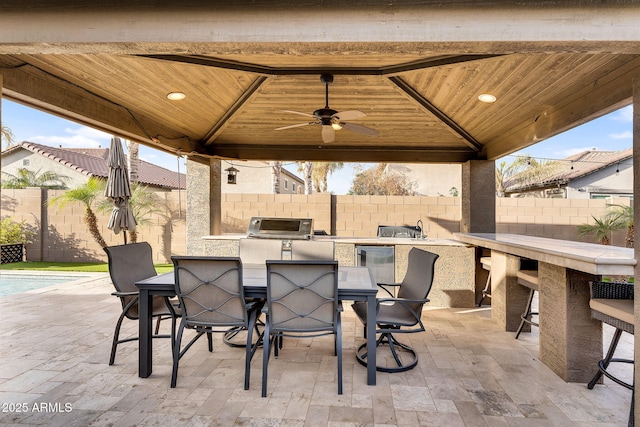 view of patio / terrace with outdoor dry bar, a gazebo, a fenced backyard, outdoor dining space, and an outdoor kitchen