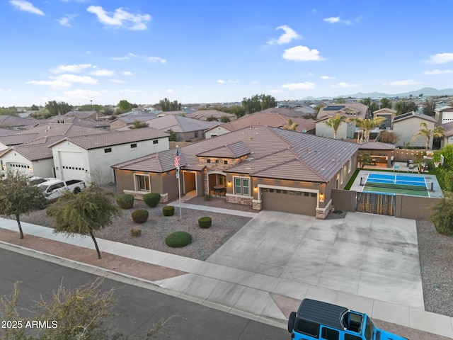 view of front of home featuring stone siding, a residential view, a garage, and fence