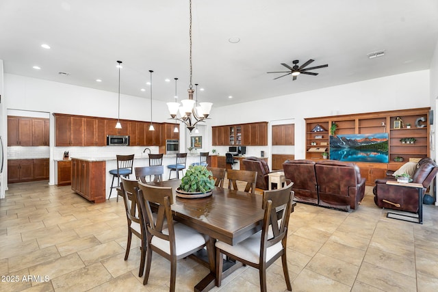 dining space with recessed lighting, visible vents, a high ceiling, and ceiling fan with notable chandelier