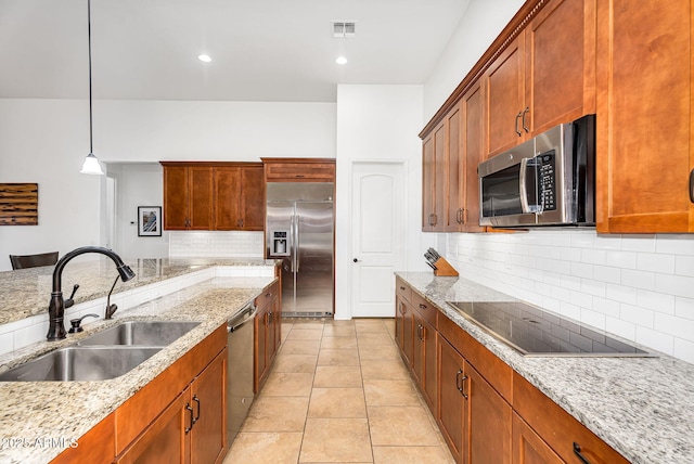 kitchen with visible vents, a sink, stainless steel appliances, light tile patterned floors, and light stone countertops