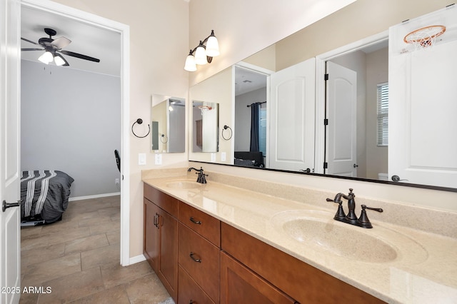 full bathroom with a sink, baseboards, double vanity, and a ceiling fan