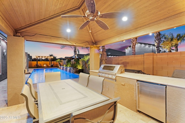 view of patio with grilling area, exterior kitchen, a gazebo, a fenced backyard, and outdoor dining space