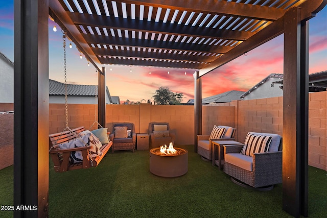 patio terrace at dusk with an outdoor living space with a fire pit, a yard, and a fenced backyard