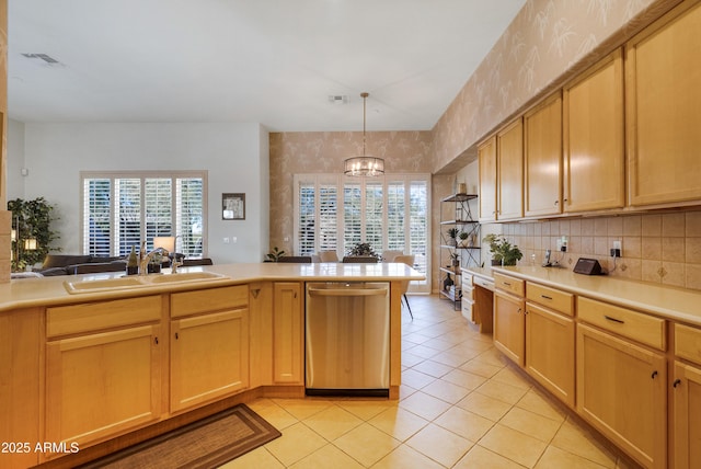 kitchen with a notable chandelier, pendant lighting, stainless steel dishwasher, sink, and light tile patterned floors